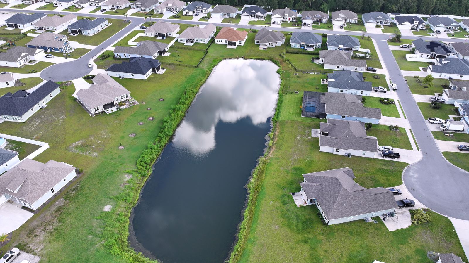 Aerial over the pond and surrounding homes